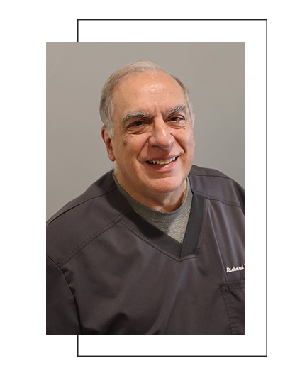 The image shows a man wearing a white coat with a stethoscope around his neck, standing in front of a light-colored background.